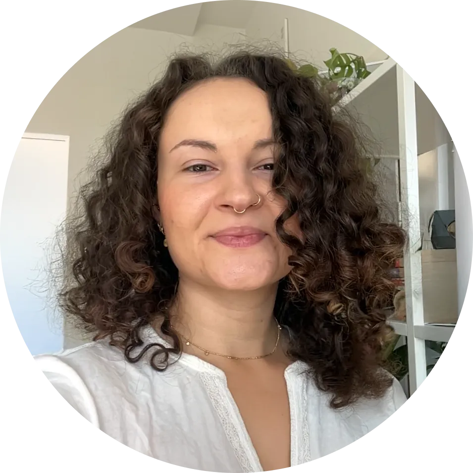 a young woman with curly hair and a soft smile